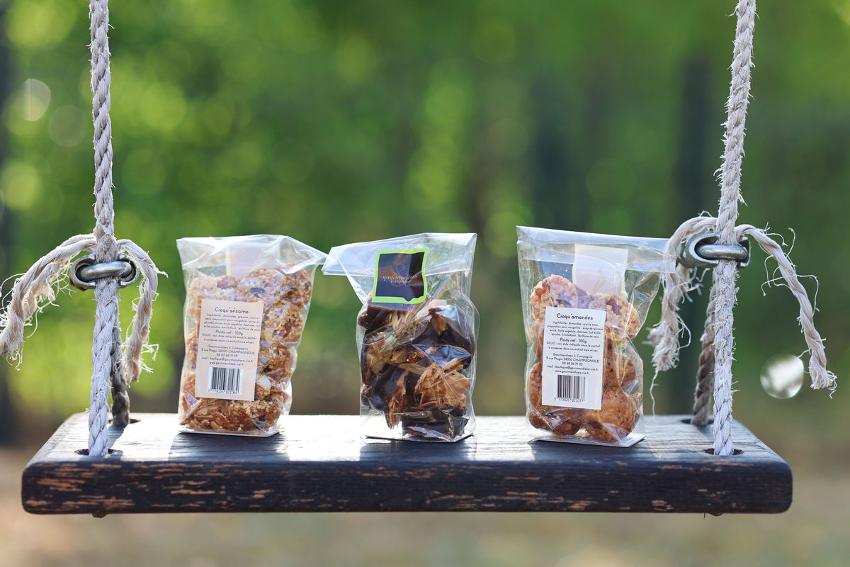 Biscuits croquants artisanaux Gourmandises & Cie, Croqu’sésame et Croqu’amandes, présentés sur une balançoire en bois