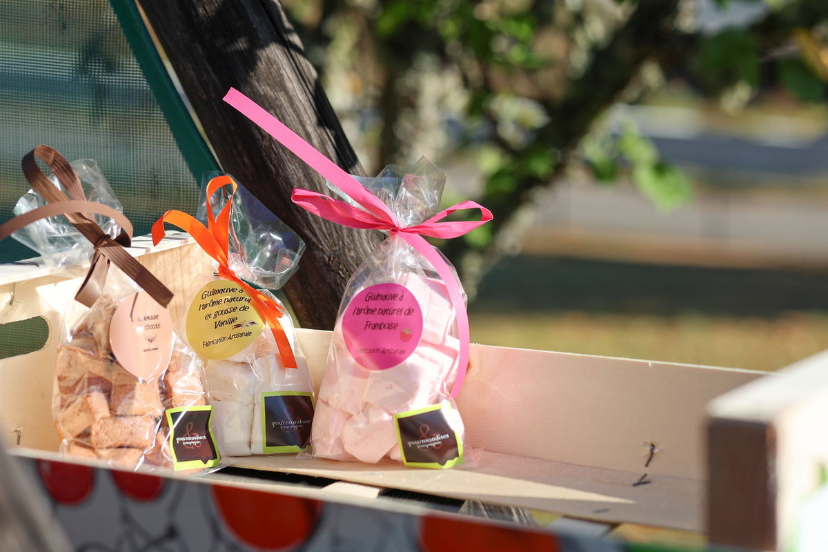 Assortiment de guimauves artisanales Gourmandises & Cie : chocolat, vanille et framboise, présentées dans une cagette en bois